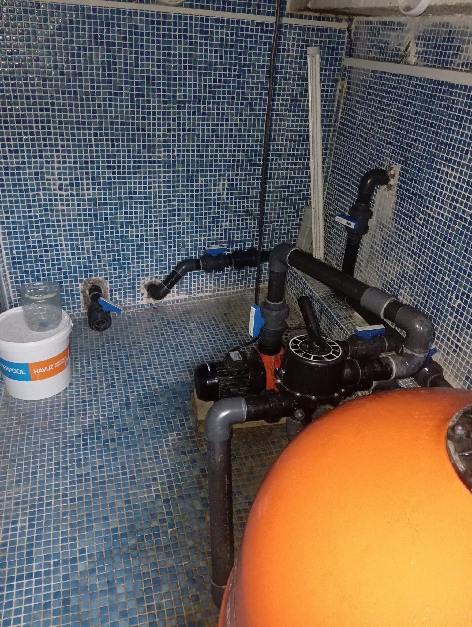 Havuz makine dairesinde filtre tankı, pompa ve vana bağlantıları